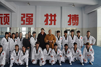 少林延鲁武术学校总教头释延鲁大师与世界冠军陈中和跆拳道队员们留影图