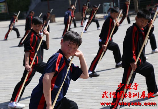 少林武校学员正在训练场上认真学习少林棍法
