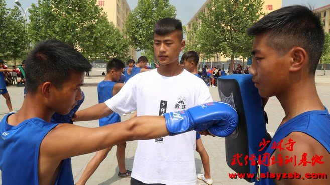 少林武术学校教练帮助学员纠正拳击动作 少林武术学校教练帮助学员纠正拳击动作