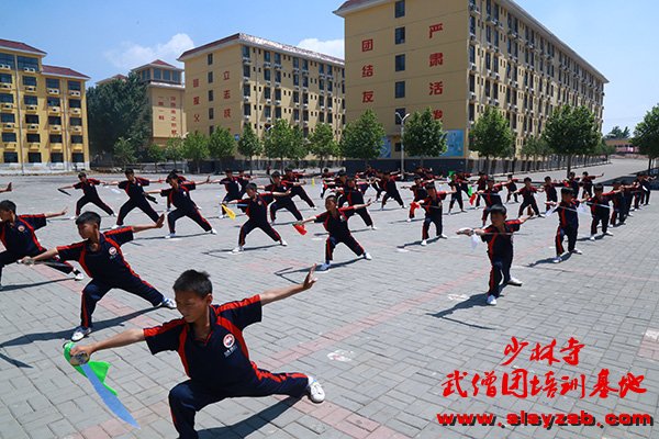 少林武术学校学员在练武场练习少林刀法 少林武术学校学员在练武场练习少林刀法