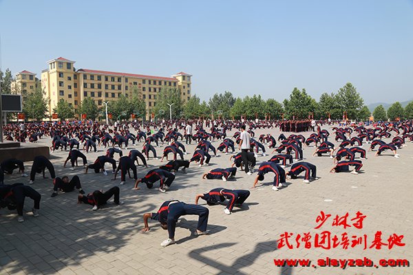 少林武校学员在练武场集体下腰